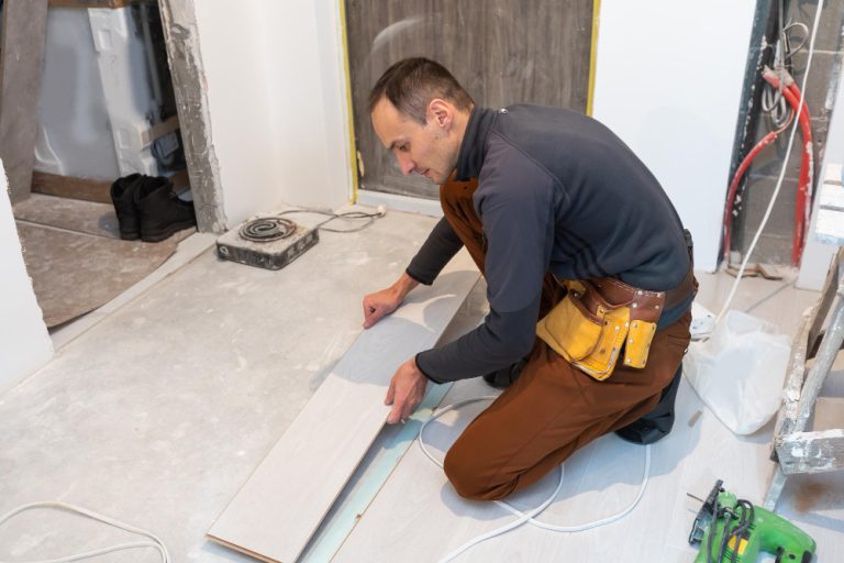 carpenter-worker-installing-laminate-flooring-room