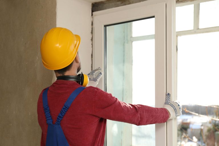 worker-uniform-installing-plastic-window-indoors